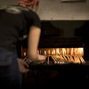An image of a student placing glass in oven